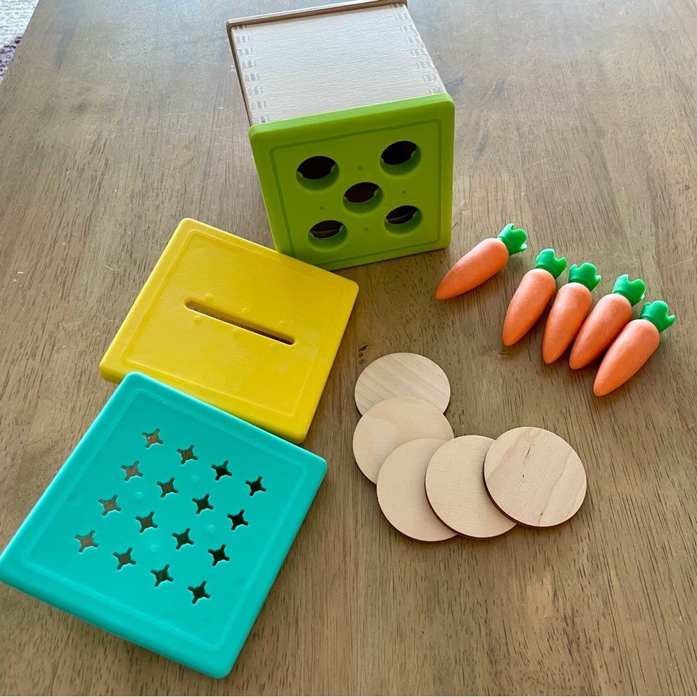 Lovevery wooden coin box with three lids, coins, and carrots